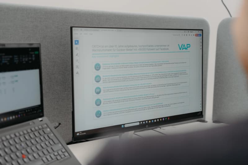 A computer screen showing a presentation titled 'CATCH' with the VAP logo in an office.