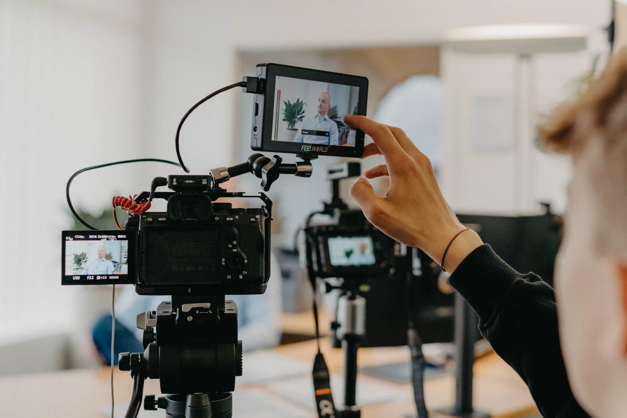 K&R behind the scenes: hand adjusting a monitor on a video camera
