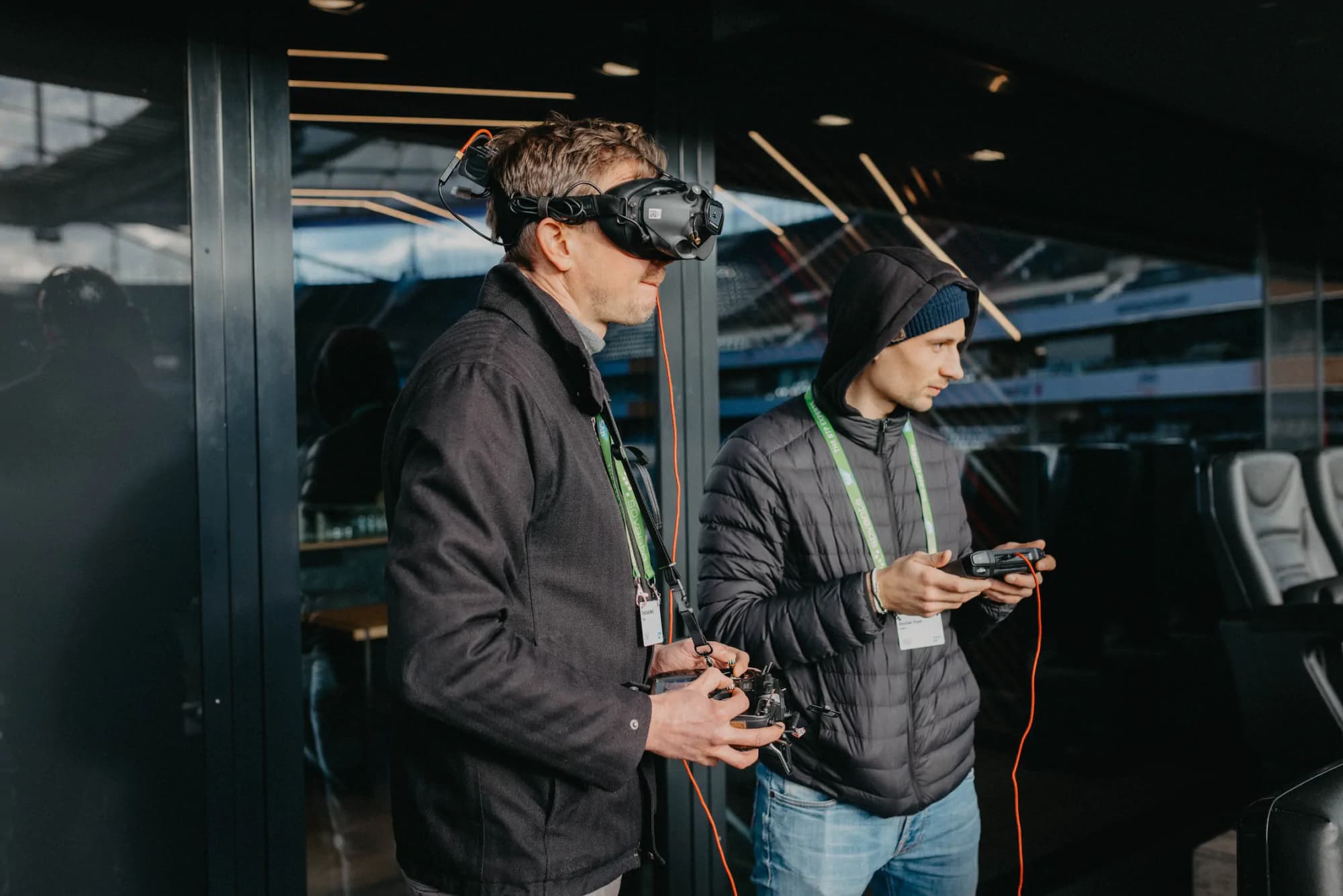 SAP behind the scenes: two men with drone and VR headset in front of a glass building