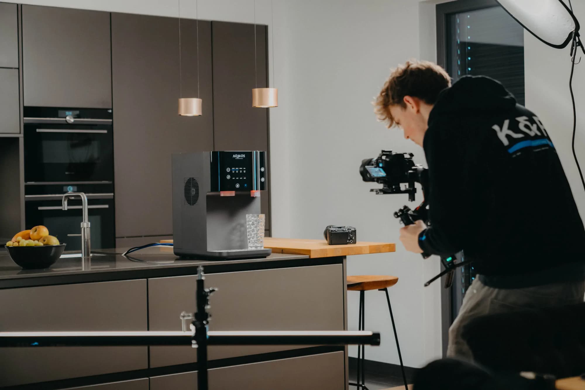 AQMOS behind the scenes: cameraman filming a water dispenser with a light tent