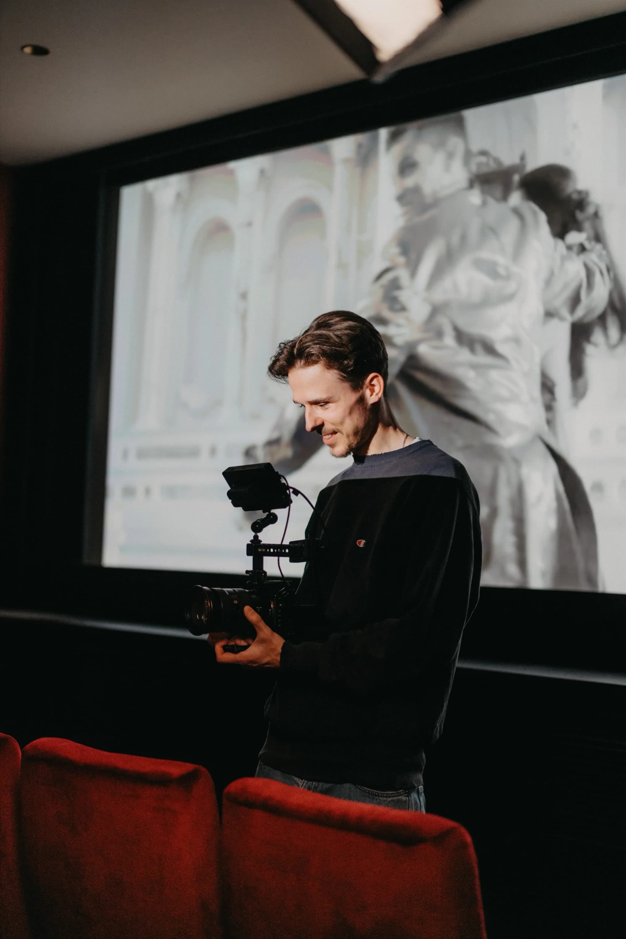K&R behind the scenes: cameraman with a video camera in front of a cinema screen